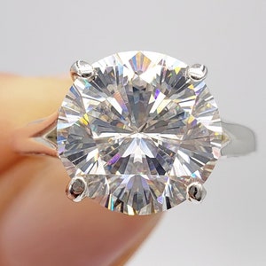 Puede incluir: Un anillo de plata con un gran diamante redondo, claro y brillante.