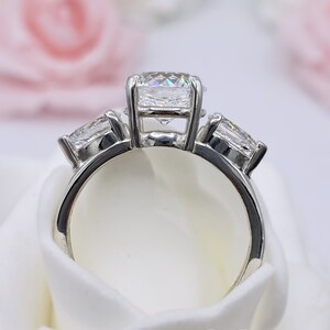 May include: A silver ring with three round diamonds. The center diamond is larger than the two side diamonds.