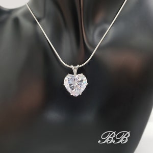 May include: A silver chain necklace with a large, clear heart-shaped pendant.