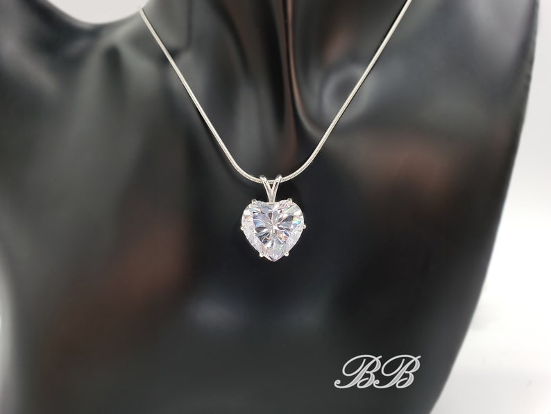 May include: A silver chain necklace with a large, clear heart-shaped pendant.