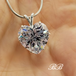 May include: A silver chain necklace with a large, clear heart-shaped pendant.