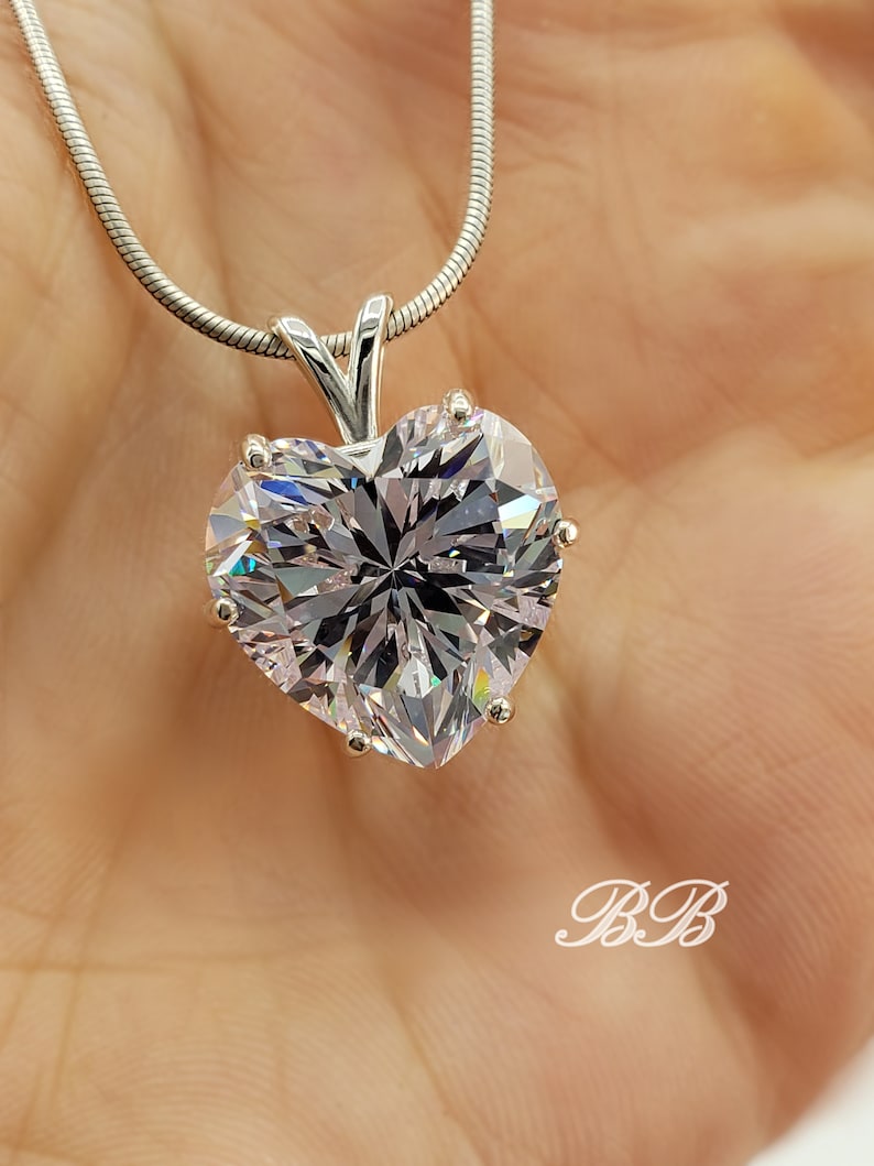 May include: A silver chain necklace with a large, clear heart-shaped pendant.