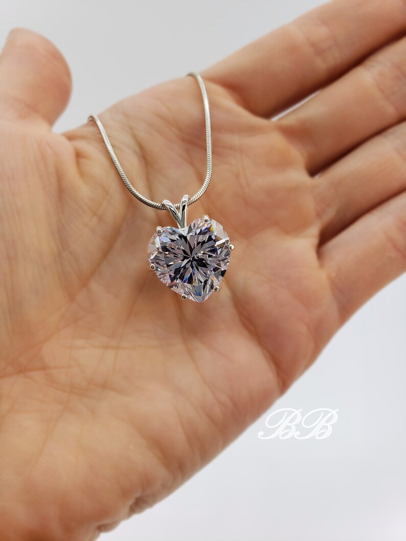 May include: A silver chain necklace with a large, clear heart-shaped pendant.