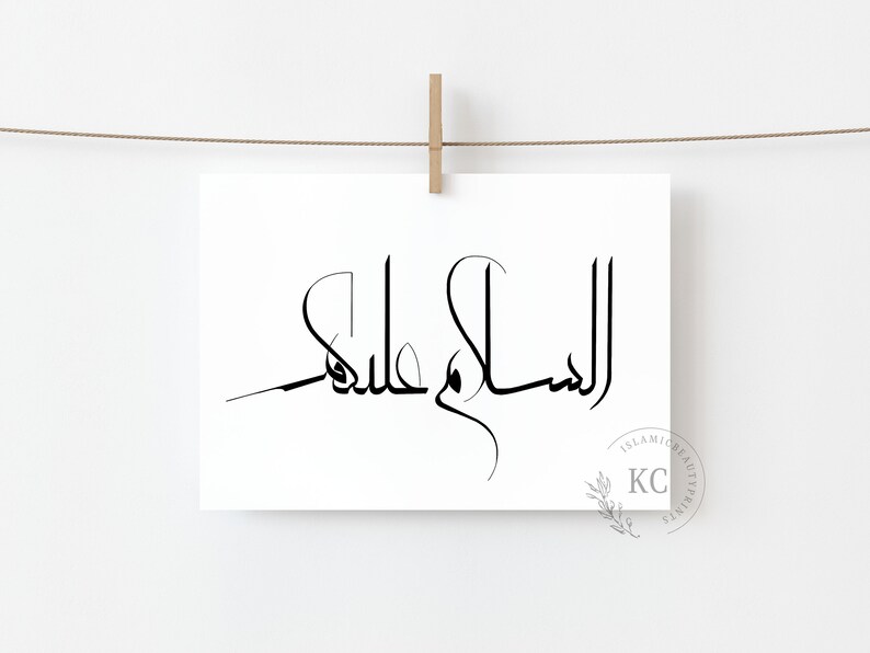 May include: A black and white print of the Arabic phrase "Assalamu Alaikum" meaning "Peace be upon you" in a modern calligraphy style. The print is hanging on a white wall with a wooden clothespin.