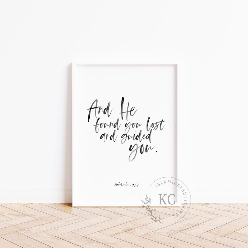 May include: Black and white calligraphy print with the text "And He found you lost and guided you."  The text is in a modern calligraphy style. The print also includes the text "Ad-Duba, 93:7".