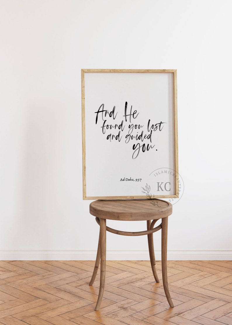 May include: A framed print with a white background and black calligraphy text that reads "And He found you lost and guided you." The text is followed by "Ad-Duba, 93:7" and a logo that reads "ISLAMIC FAMILY KC" in a black and white font.