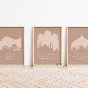 Könnte beinhalten: Drei braune gerahmte Drucke mit rosafarbenen Moscheesilhouetten und arabischem Text. Der Text übersetzt sich mit: "Die Moschee von dir ist das Recht von dir, das Recht des Herzens, die Rechtschaffenheit von dir." "Und wahrlich, unter den Menschen sind diejenigen, die sagen: "Unser Herr, gewähre uns Gutes in dieser Welt und im Jenseits, und schütze uns vor der Strafe des Feuers." "Und wahrlich, das Jenseits wird Respekt vor denen haben, die ihn fürchten, und sie werden verschont bleiben."
