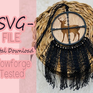 May include: A wooden deer silhouette within a black crosshair design, with a black fringe. The text "SVG FILE Digital Download Glowforge Tested" is visible. The item is hanging on a woven background.