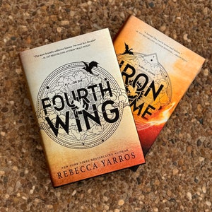 May include: Two fantasy novels, "Fourth Wing" and "Iron Flame", by Rebecca Yarros. The covers feature dragons and a fiery background.
