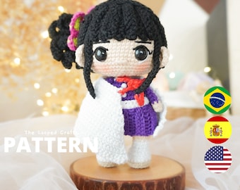 May include: Crochet amigurumi doll pattern featuring a character with black hair, a white shawl, a purple dress, and a red ribbon. The doll is standing on a wooden base. The text "The Looped Craft PATTERN" is visible in the image.