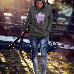 May include: A gray hooded sweatshirt with a geometric design featuring a purple mountain landscape and the word "Explore".