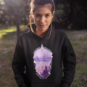 May include: Black hoodie with a geometric design featuring a purple and pink watercolor landscape. The design includes the text "EXPLORE THE ART OF LIVING" and "ETERNAL SUNRISE", "ETERNAL SUNSET", "ETERNAL DAWN", and "AND GLOAMING".