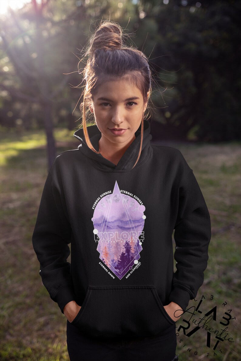 May include: Black hoodie with a geometric design featuring a purple and pink watercolor landscape. The design includes the text "EXPLORE THE ART OF LIVING" and "ETERNAL SUNRISE", "ETERNAL SUNSET", "ETERNAL DAWN", and "AND GLOAMING".