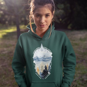 May include: A dark green hooded sweatshirt with a graphic print of a mountain landscape. The graphic features a geometric design with the words "Eternal Sunrise", "Eternal Sunset", "Explore", "Eternal Dawn", and "And Gloaming".