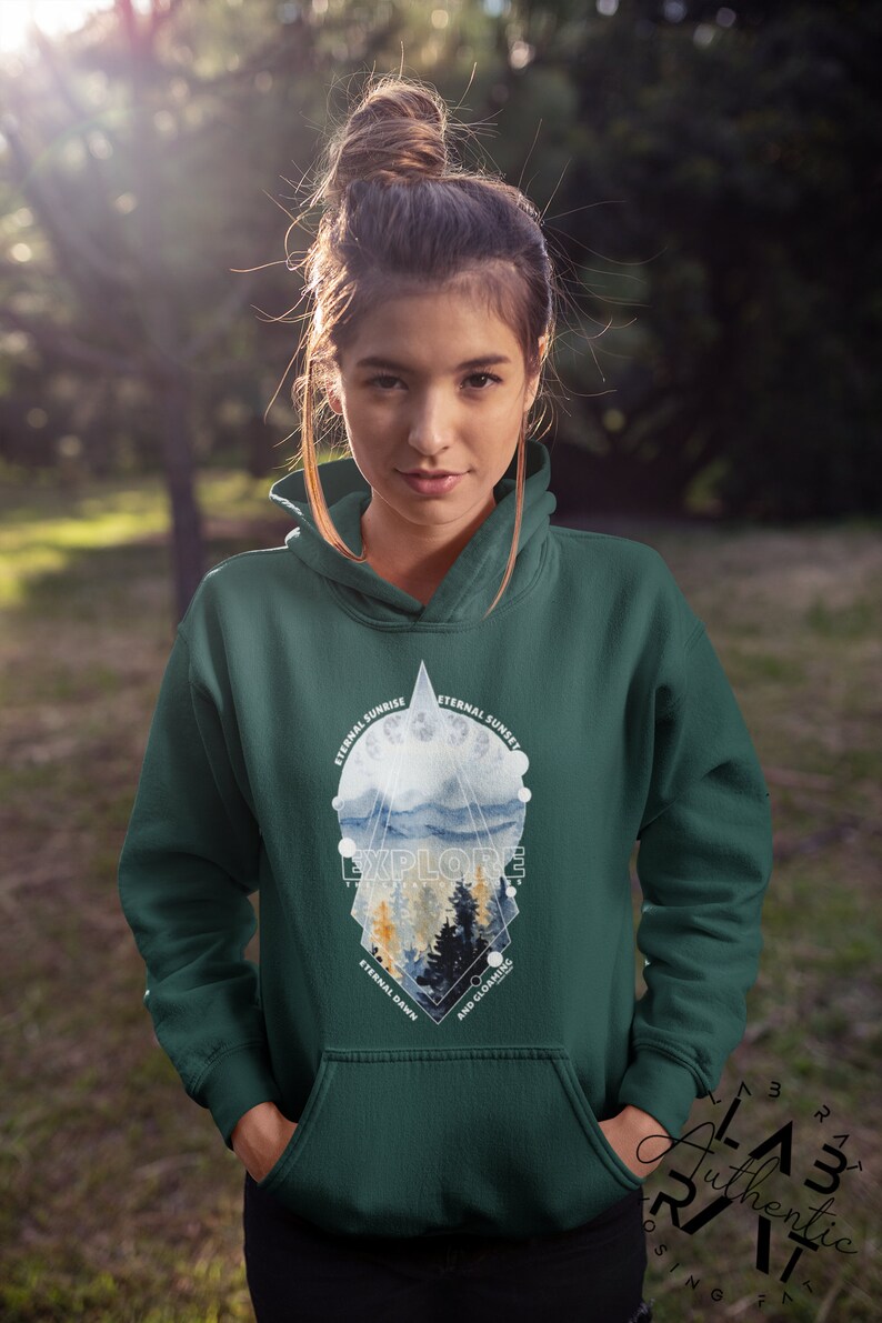 May include: A dark green hooded sweatshirt with a graphic print of a mountain landscape. The graphic features a geometric design with the words "Eternal Sunrise", "Eternal Sunset", "Explore", "Eternal Dawn", and "And Gloaming".