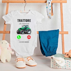 Può includere: Un body bianco per neonato con un grafico di trattore verde e il testo "TRATTORE sto chiamando" con un'icona di telefono verde che dice "rispondi" e un'icona di telefono rosso che dice "rifiuta". Il testo sotto le icone dice "E IO DEVO ANDARE".