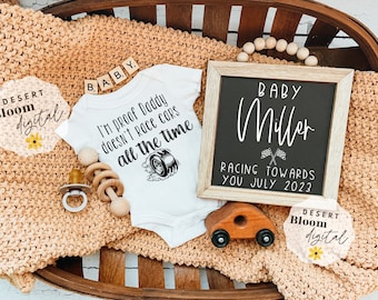 May include: A baby announcement with a white onesie that reads "I'm proof Daddy doesn't race cars all the time." A chalkboard sign says "Baby Miller Racing Towards You July 2023." Wooden toys and a pacifier are included.