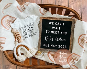 Puede incluir: Un body blanco con el texto "Made with Love and a Little Science" en letras negras. Un tablero de letras con el texto "We can't wait to meet you Baby Wilson Due May 2023" en letras blancas. Una cesta de mimbre marrón con una manta blanca con un patrón de arcoíris marrón y naranja.