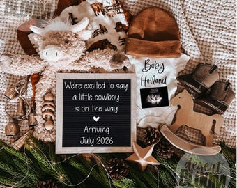 May include: An announcement with a cowboy theme. Includes a letter board with text, a plush toy, a baby onesie, a beanie, baby cowboy boots, and a wooden rocking horse. The letter board says "We're excited to say a little cowboy is on the way. Arriving July 2026."