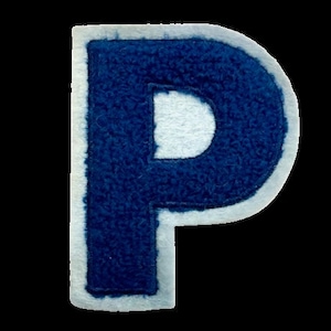 Op de afbeelding: Een blauwe letter "P" patch met een witte rand. De letter heeft een getextureerde, fuzzy uitstraling en de witte rand zorgt voor een helder contrast met het donkerblauw. De patch is waarschijnlijk voor kleding of ambachten.