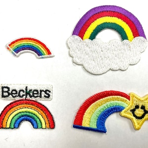 May include: Four embroidered rainbow patches. One rainbow patch is in a cloud shape. One rainbow patch has a star with a smiley face. One rainbow patch has the word "Beckers" on it.