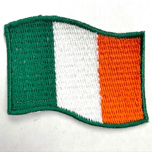 May include: A green, white, and orange embroidered Irish flag patch. The flag is waving in the wind.