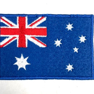 May include: An embroidered patch of the Australian flag. The flag is blue with a red Union Jack in the top left corner and a constellation of white stars in the bottom right corner.