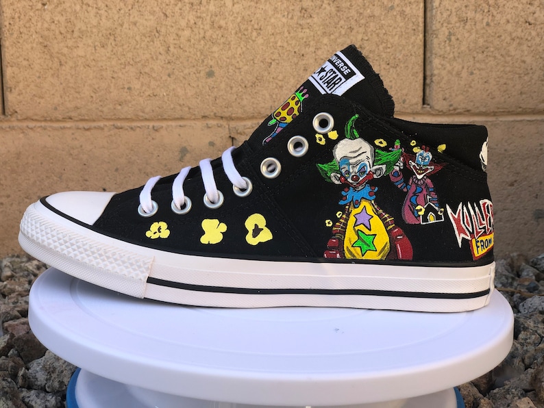 May include: Black high-top Converse sneakers with a custom design featuring clowns, popcorn, and the text "Killjoy From Outer Space".