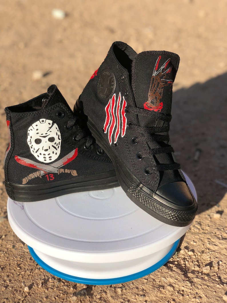 May include: Black high-top trainers with hand-painted designs inspired by the horror films Friday the 13th and A Nightmare on Elm Street. One trainer features Jason Voorhees' hockey mask and a machete, while the other trainer features Freddy Krueger's clawed glove.