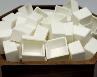 May include: A wooden tray filled with white ceramic paint pans. The pans are arranged in a random pattern and are all the same size.