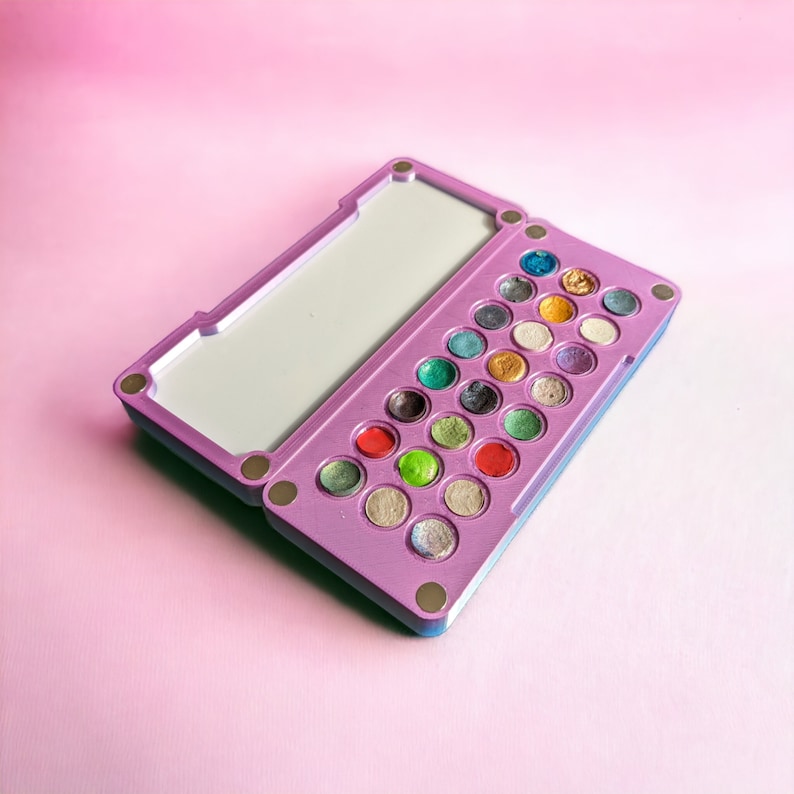 May include: A purple and blue makeup palette with a mirror lid and 24 round, colourful eyeshadows.