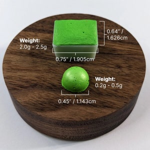 Pu&ograve; includere: Due saponette fatte a mano, di colore verde e macchiate. La saponetta pi&ugrave; grande &egrave; quadrata e pesa da 2,0 a 2,5 grammi. La saponetta pi&ugrave; piccola &egrave; rotonda e pesa da 0,2 a 0,5 grammi. Entrambe le saponette sono su una superficie di legno.