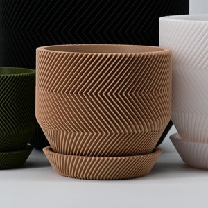 May include: Four different sized planters with a chevron pattern. The planters are in black, green, brown, and white.