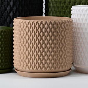 May include: Four geometric planter pots in different sizes and colors: black, green, beige, and white. The pots have a diamond-shaped pattern and are made of plastic.