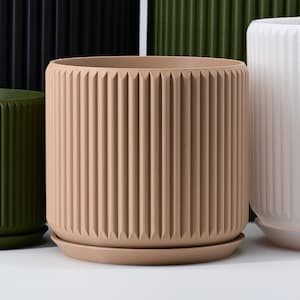 May include: Four different sized, cylindrical plant pots with a ribbed design. The pots are black, green, beige, and white.