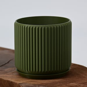 May include: A dark green planter with a ribbed design and a matching saucer. The planter is made of plastic and has a modern, minimalist style.