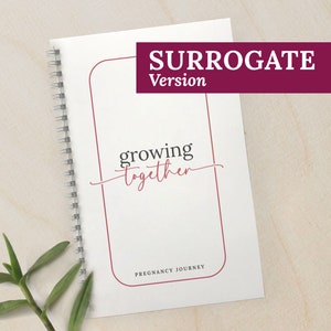 May include: A white spiral bound journal with a red border and the text "growing together" in cursive. The text "SURROGATE Version" is at the top of the journal. The journal has the text "PREGNANCY JOURNEY" at the bottom.