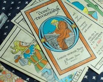 May include: A vintage tarot card deck with a blue and orange design. The card features a man writing at a desk. The card is titled "IVDVS TRIVMPHORVM" and is part of a limited edition set of 250 cards. The card is signed by Carlos Dorian.