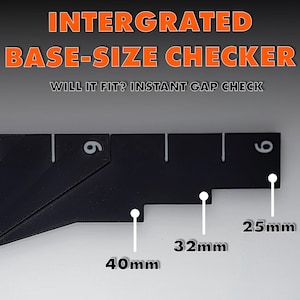Op de afbeelding: Een zwarte basisgrootte checker met de tekst "INTERGRATED BASE-SIZE CHECKER" en "WILL IT FIT? INSTANT GAP CHECK". De checker heeft afmetingen van 40 mm, 32 mm en 25 mm. Het nummer 6 is zichtbaar.