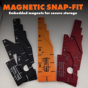 Op de afbeelding: Drie magnetische snap-fit game-accessoires in zwart, oranje en rood. Elk stuk heeft genummerde markeringen en de tekst "KILL TEAM". De bovenste tekst luidt "MAGNETIC SNAP-FIT" en "Embedded magnets for secure storage".