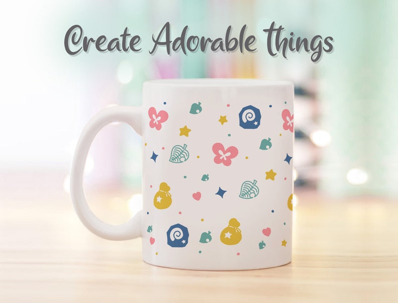 May include: White ceramic mug with a pattern of pink flowers, yellow stars, green leaves, blue and white shells, and yellow money bags. The text "Create Adorable Things" is written in gray at the top of the mug.