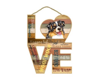 May include: Wooden sign shaped like the word "LOVE" with a heart in the middle. The heart features a brown and white Australian Shepherd dog. The letters are decorated with words related to dogs, such as "woof", "best friend", "long walks", and "sloppy kisses".