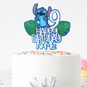 K&ouml;nnte beinhalten: Ein Tortenaufsatz mit der Figur Stitch aus Lilo & Stitch, mit der Zahl 9 und den Worten "HAPPY BIRTHDAY NAME" in blauem Glitzer. Der Aufsatz befindet sich auf einer wei&szlig;en Torte, die mit bunten Streuseln verziert ist, mit Cupcakes im Hintergrund.