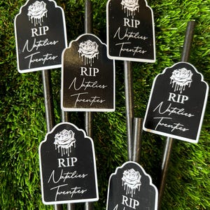 May include: Six black and white paper straws with a tombstone-shaped sticker that says "RIP Natalies Twenties". Each sticker has a black rose with dripping water.