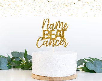 May include: Gold glitter cake topper with the text "Name Beat Cancer".