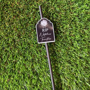 May include: Black and white tombstone-shaped straw topper with the text "RIP Napties Twenties".