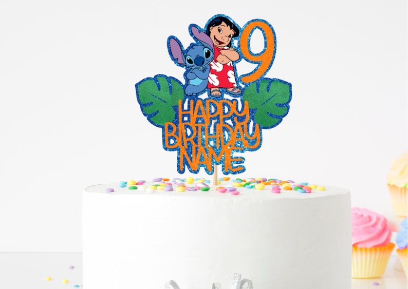 K&ouml;nnte beinhalten: Ein Tortenaufsatz mit den Figuren Lilo und Stitch, sowie der Zahl 9. Der Aufsatz hat einen blauen Glitzerumriss und den Text "Happy Birthday Name" in Orange. Der wei&szlig;e Kuchen ist mit bunten Streuseln verziert. Ideal f&uuml;r einen Geburtstag.