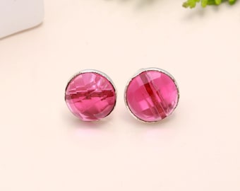 Puede incluir: Un par de pendientes de botón de plata con piedras preciosas facetadas de color rosa.