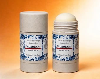 May include: Two beige deodorant sticks with a blue and white floral label. The label reads Dutch Heritage Cosmetics, DEODORANT, SEDUCTION, and Net 75ml | 2.54 fl oz. One stick is capped, and the other is open, revealing a solid white deodorant.