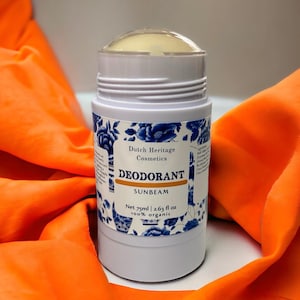 Peut inclure: Un stick de déodorant blanc avec un motif floral bleu et blanc. L'étiquette indique "Dutch Heritage Cosmetics Deodorant Sunbeam Net 75ml | 2.63 fl oz 100% organic"